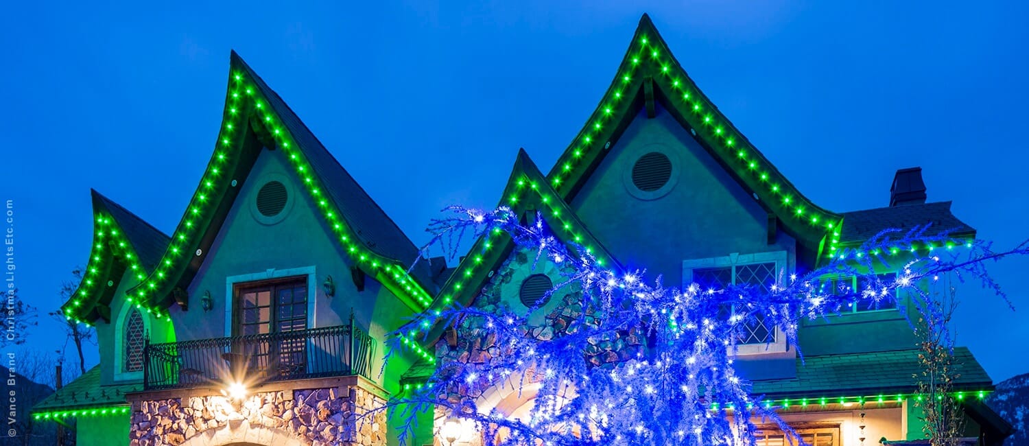House's roof line decorated with Christmas lights