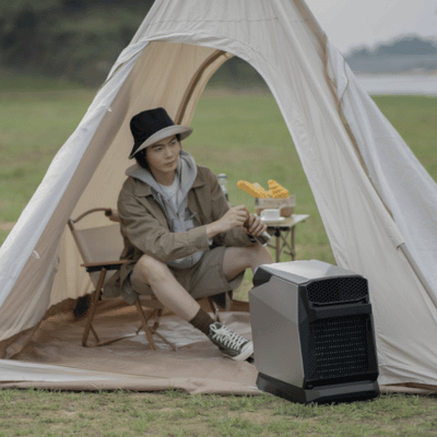 Woman enjoying a portable tent air conditioner in her tent