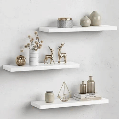 White floating wood shelves installed on a wall