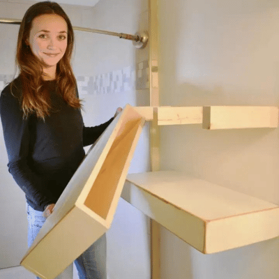 Woman installing a floating wood shelf
