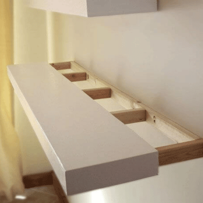 Floating wood shelf being installed on the frame