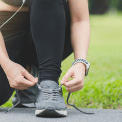 Woman lacing up her running shoes