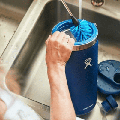 Person cleaning a wide-mouth stainless steel water bottle