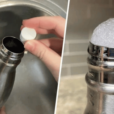 Person cleaning a stainless steel water bottle with cleaning tablets