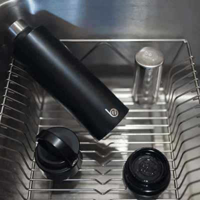 Stainless steel water bottle drying in a rack after cleaning