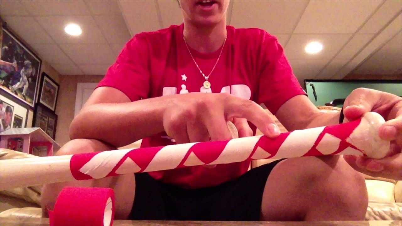 Man pointing to the pattern of a taped wiffle ball bat