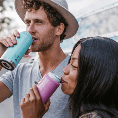 Woman and a man drinking water from a stainless steel water bottle