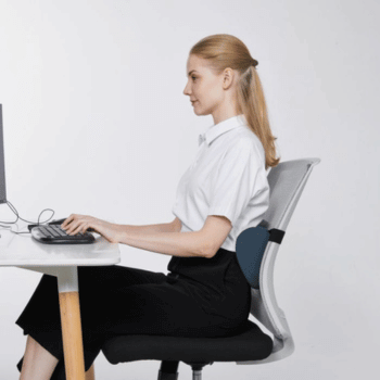 Woman at a desk with additional lumbar support cushion