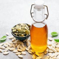 Pumpkin seed oil amid a dish of pumpkin seeds