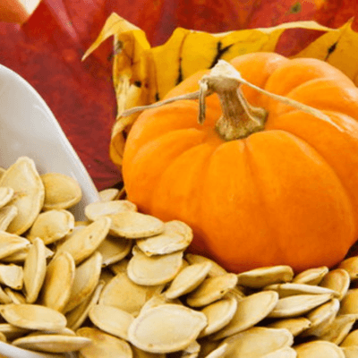 Raw pumpkin seeds and a pumpkin