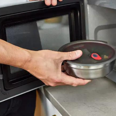 Stainless steel bowl being placed in a microwave oven