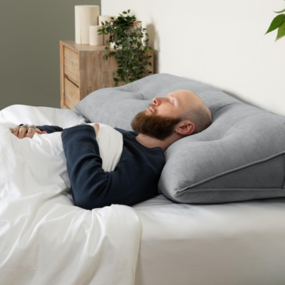Man sleeping on a QE Home Horizontal Wedge Pillow