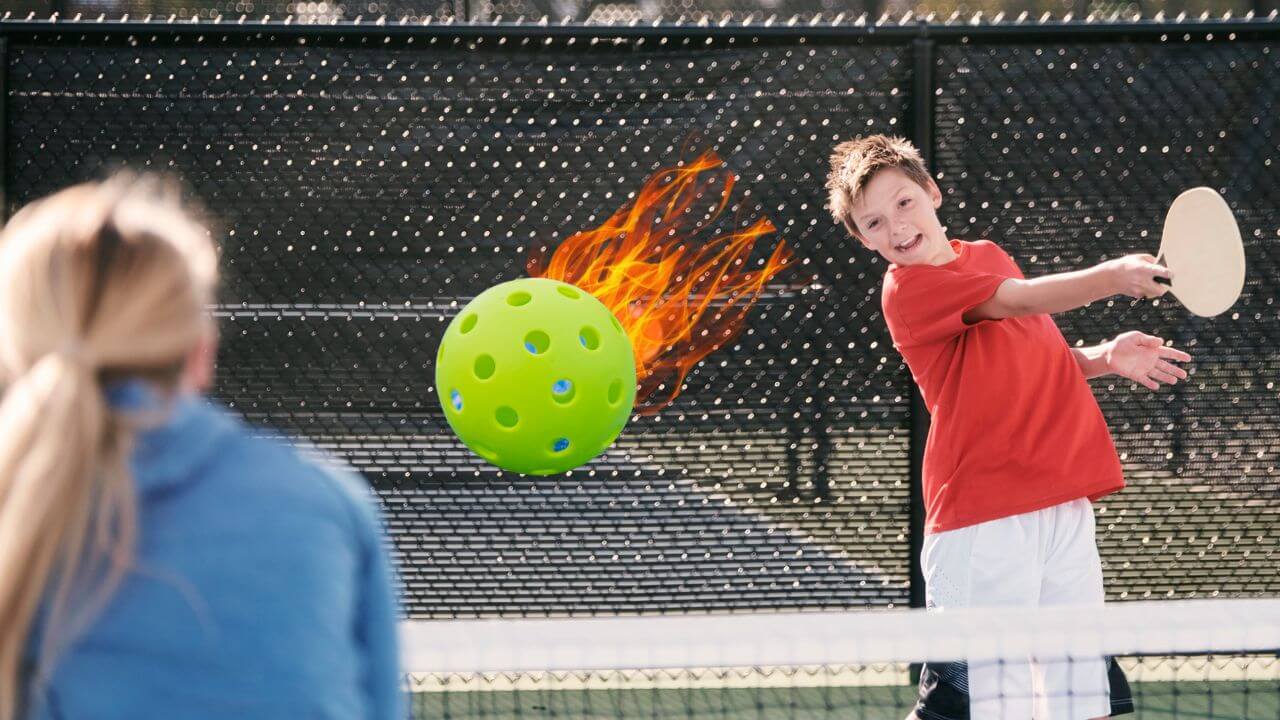 Boy swatting a flaming pickleball at his opponent