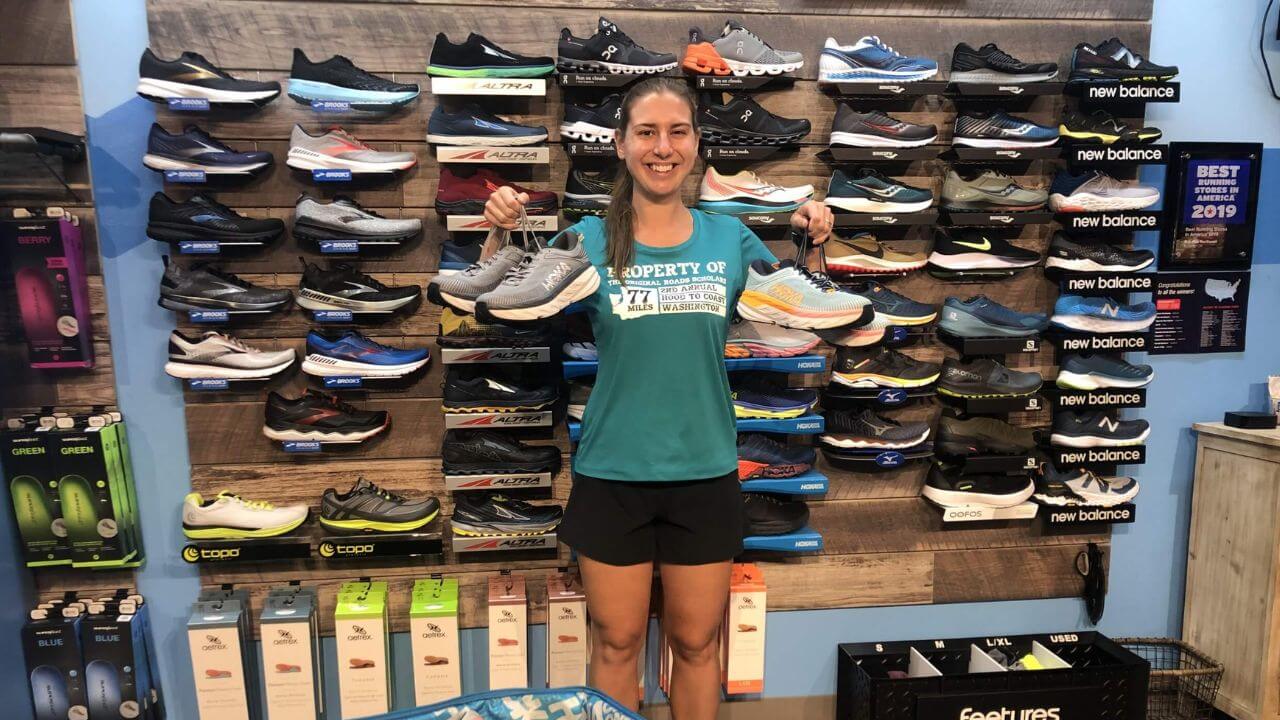 A woman showing different types of sports shoes suitable for pickleball