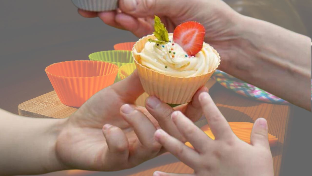 Hand presenting a cupcake in a non-stick liner
