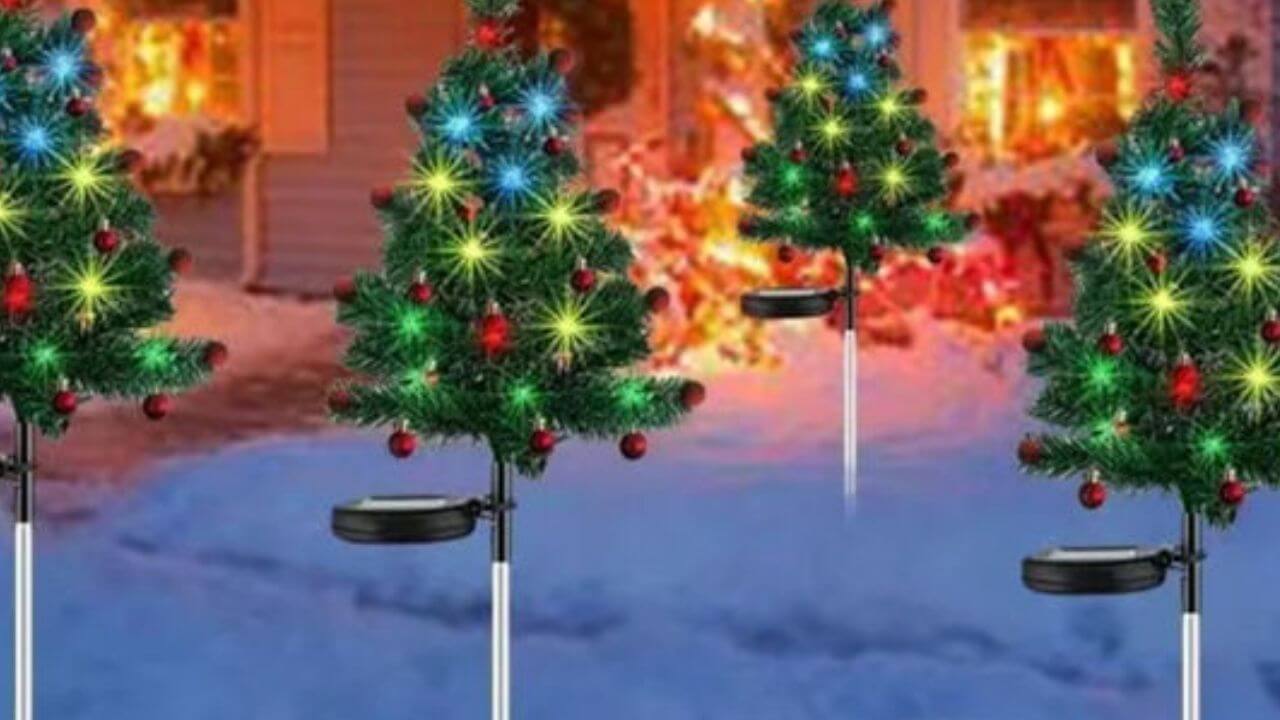 Group of four tree solar outdoor Christmas decorations in a snow-covered yard