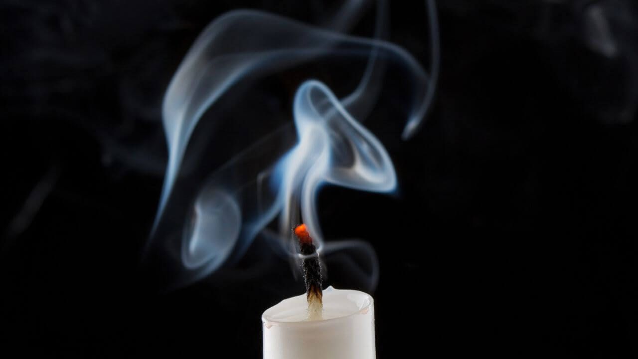 Smoking candle extinguished without a candle snuffer