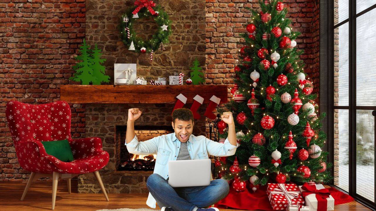 Person sitting in front of a fire place and a decorated artificial Christmas tree