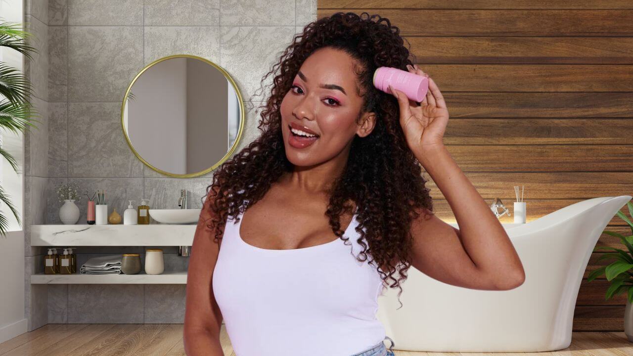 A woman applying a hair wax stick to her hair