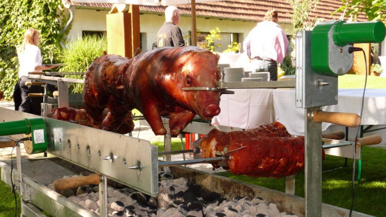 Roasting pig and cuts of beef on a spit roaster