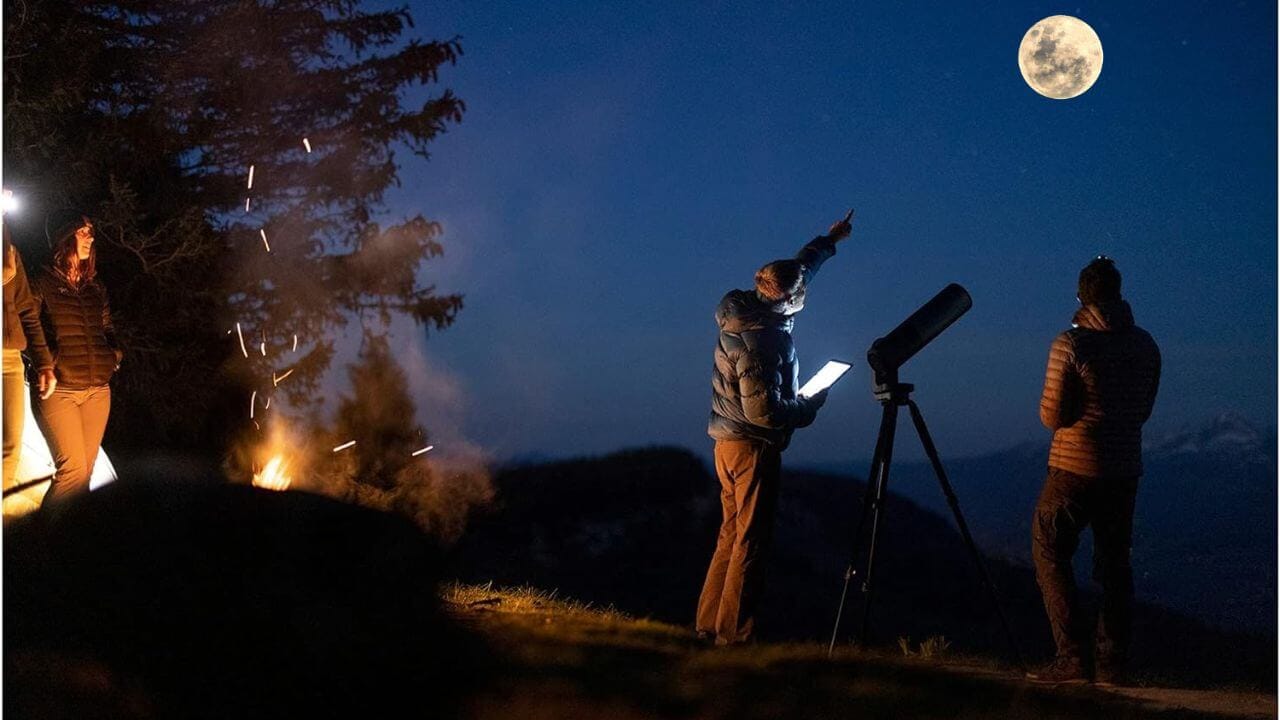 Outdoor enthusiasts gazing at the moon with a smart telescope