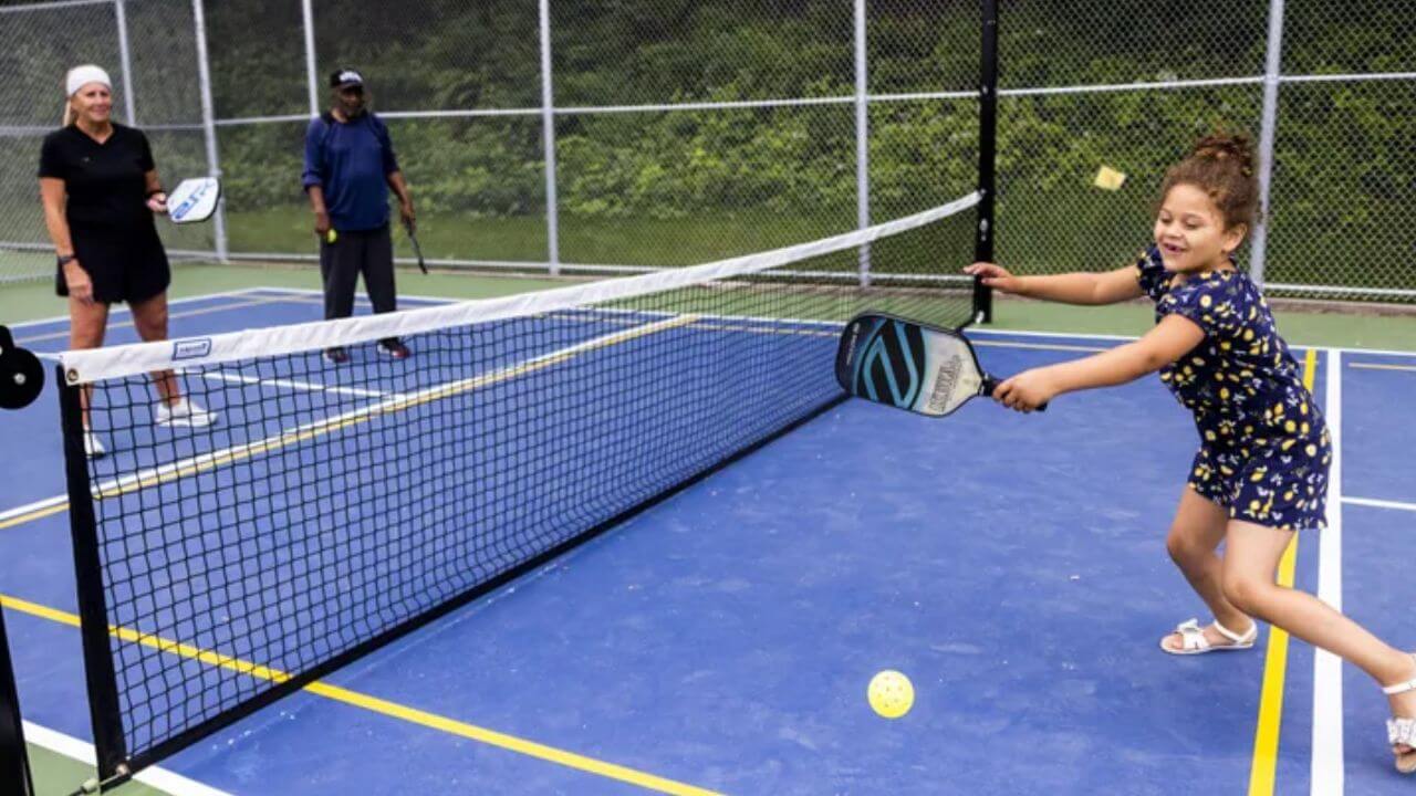 Pickleballers playing pickleball with a standard pickleball net