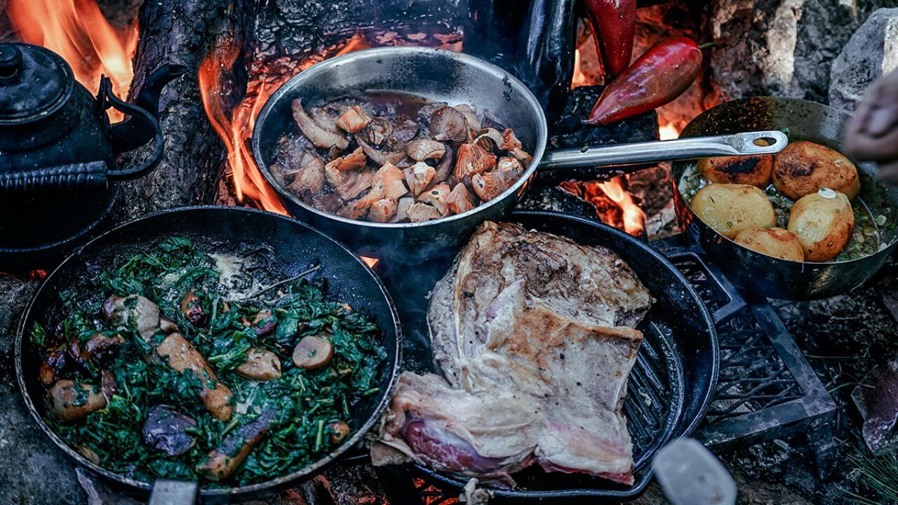 Various campfire cookware items in use while camping