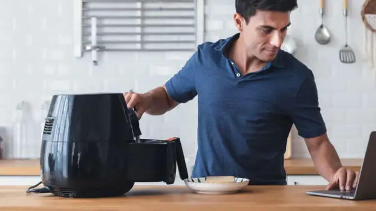 Man reading the preheat instructions for his CRUX air fryer