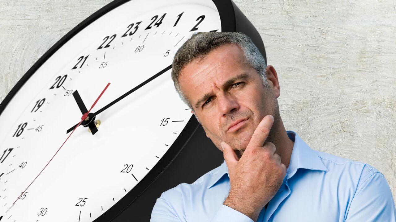 Man wondering how to read a 24-hour analog wall clock