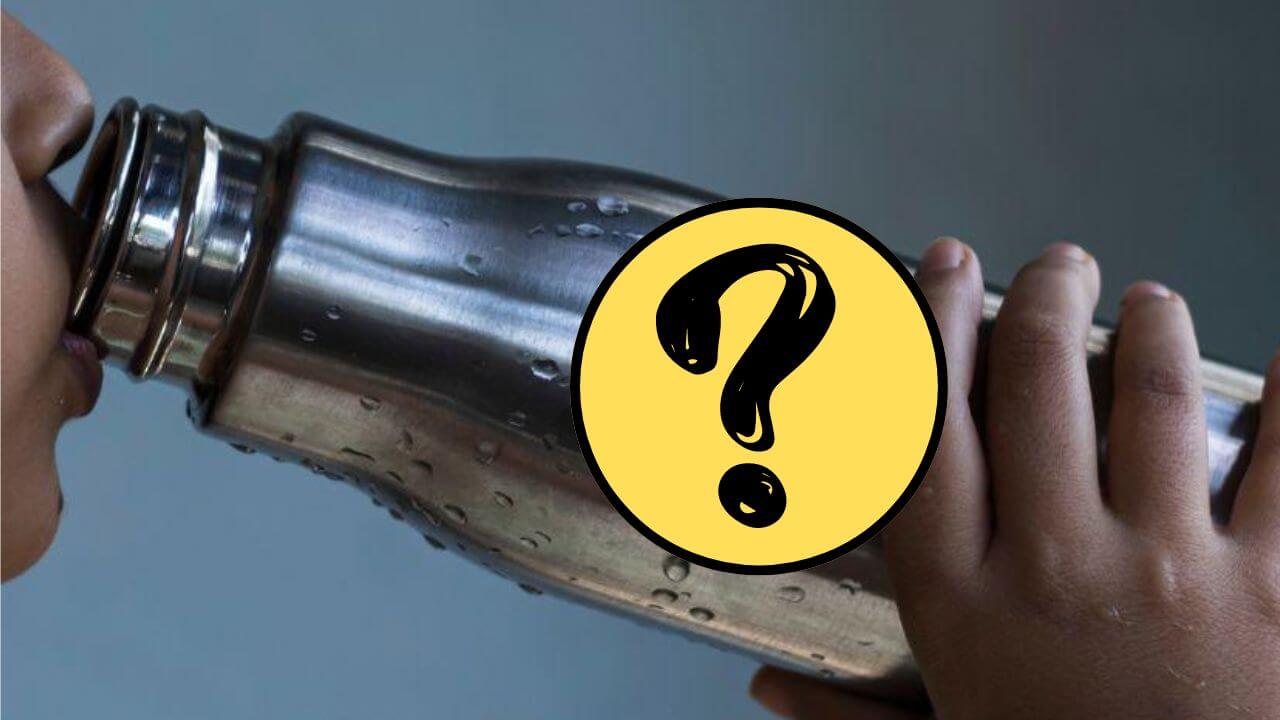 Person drinking water from a stainless steel water bottle behind a question mark