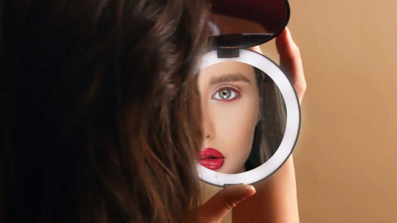 Woman looking into a compact travel mirror