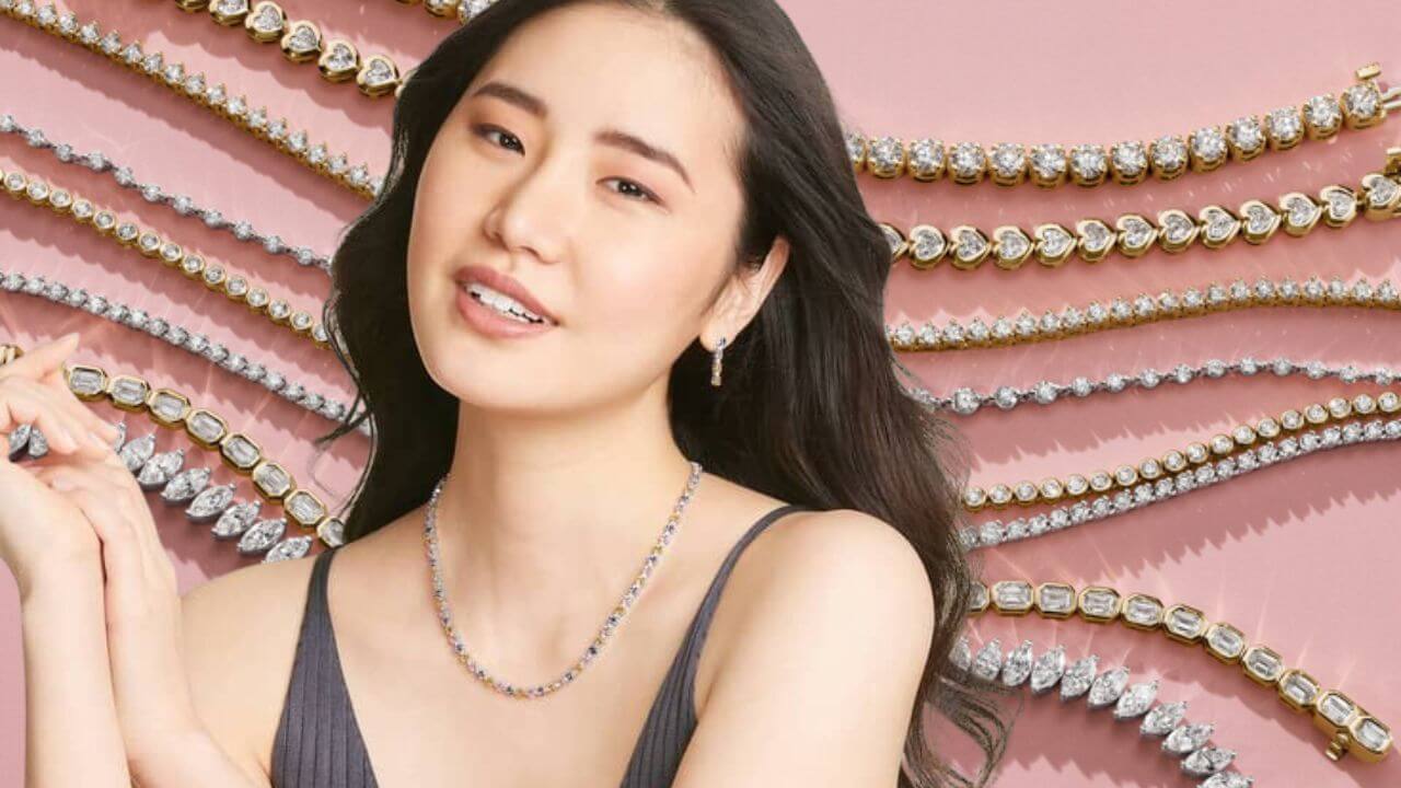 Woman wearing a tennis necklace with stings of tennis necklaces in the background