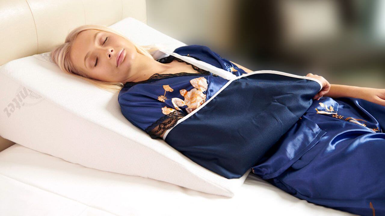 Woman resting on a wedge pillow after shoulder surgery