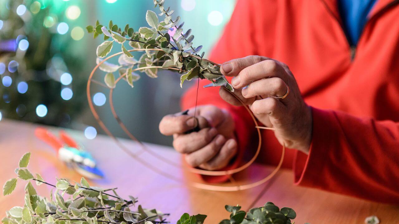 Person in the process of making a Christmas door wreath