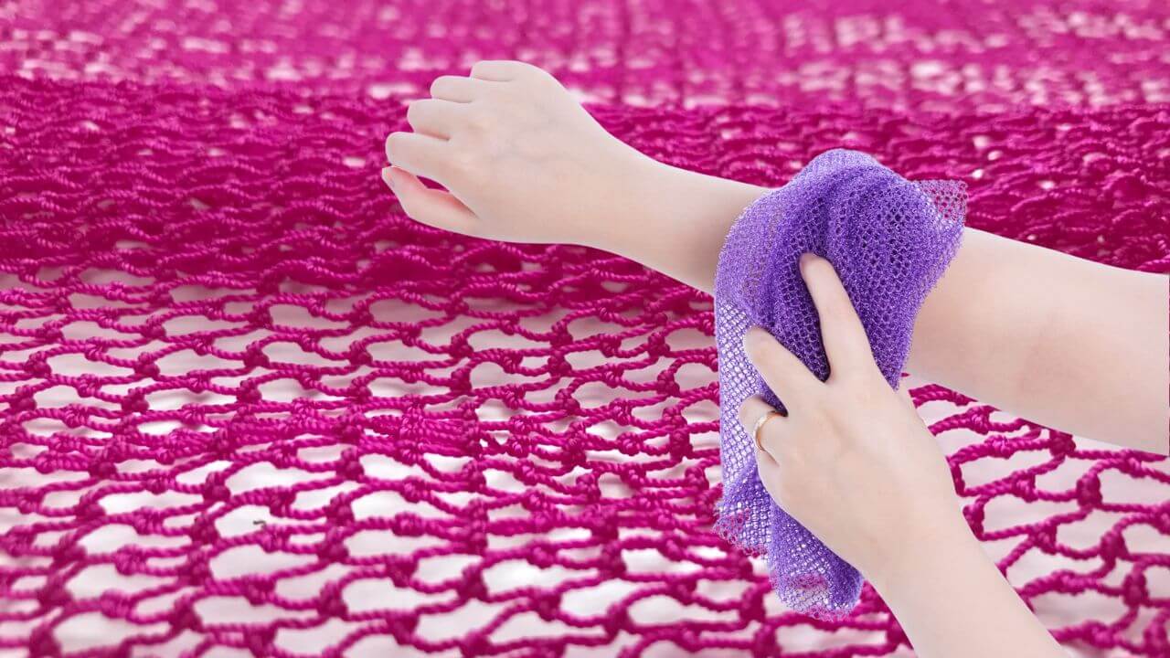 Woman using an African net sponge with a net sponge pattern in the background